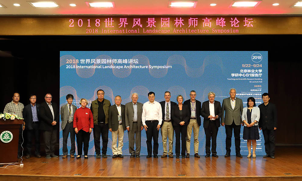 Delegates of the symposium line up for a photo on stage